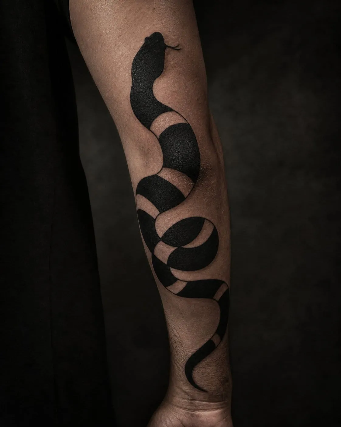 Solid blackwork snake tattoo wrapping a forearm with bold negative-space bands.